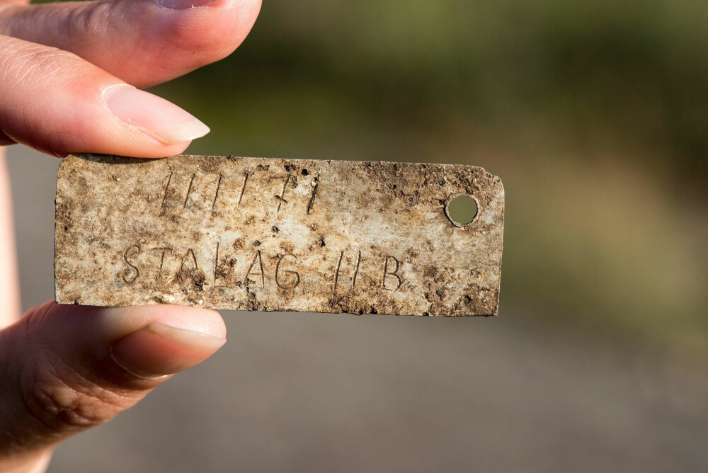 DØDSBRIKKE: Alle fangene bar en aluminiumsbrikke som identifikasjon. Denne, som ble funnet ved gravplassen, har fangenummeret 111171 inngravert.