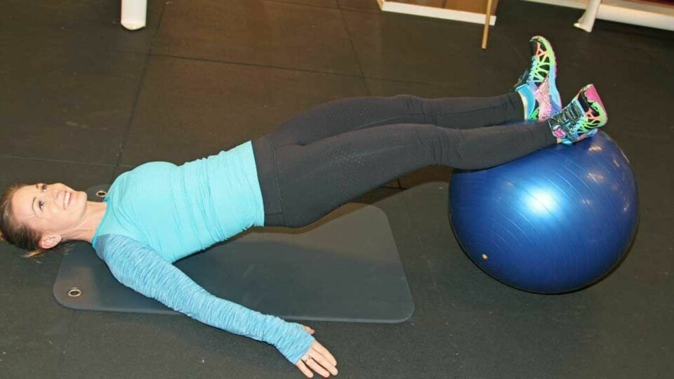 Mariann demonstrerer legcurl på ball.