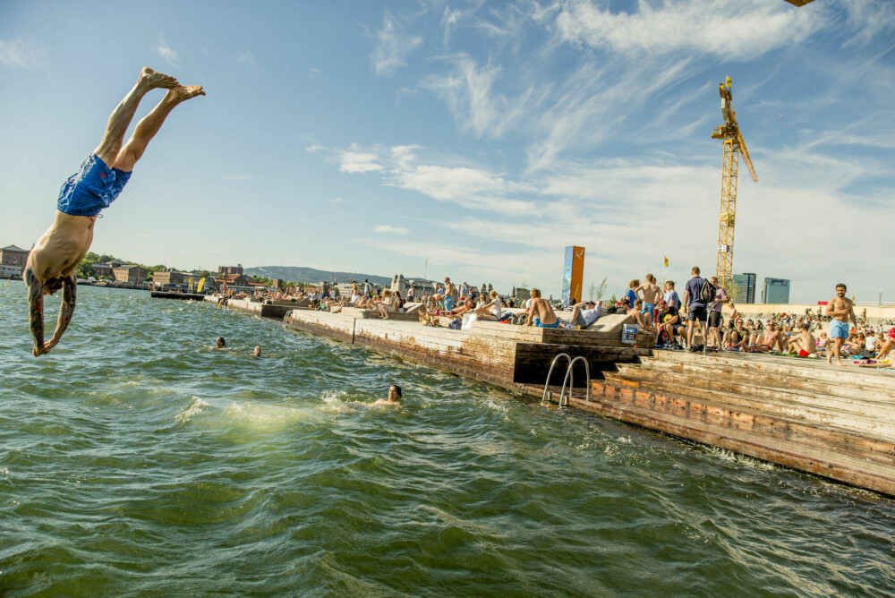 Folk nyter sol, sommer og bading på Sørenga i Oslo.