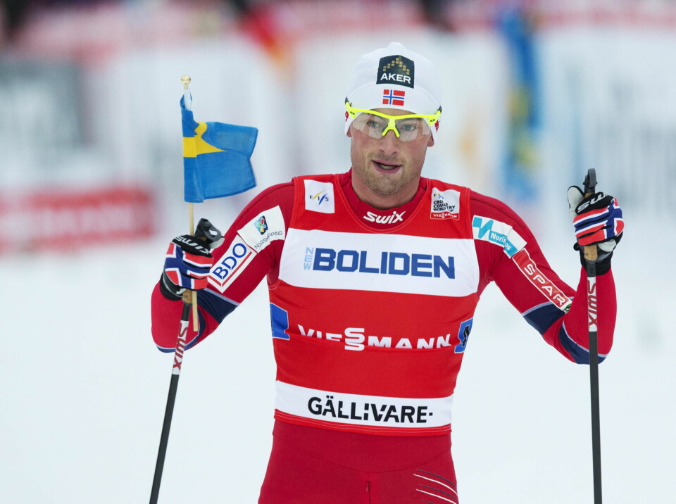 SKIKONGEN: Petter Northug krysser mållinjen med det svenske flagget i hånden.