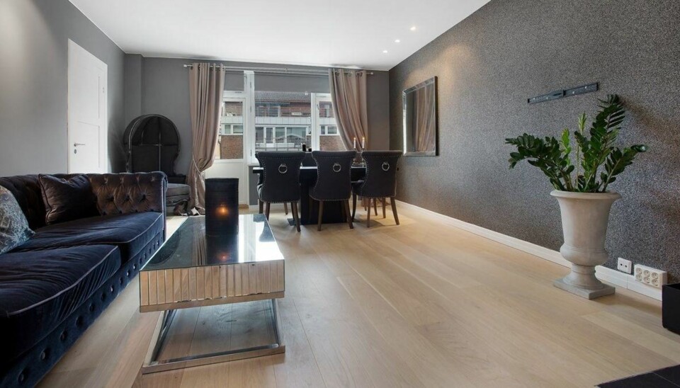 Stuen sett fra motsatt side. Sofa i forgrunn og spisebord i bakgrunn.