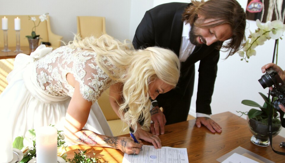 TRYKK FOR STØRRE BILDE. Her signerer det ferske ekteparet på papirene som gjør dem til rette ektefeller.