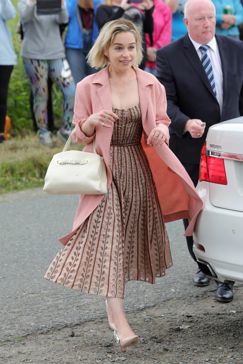 KOLLEGA: Emilia Clarke ankommer kirken hvor Kit Harington og Rose Leslie giftet seg 23. juni. Skuespillerstjernen kom i en nydelig gammelrosa kjole. 