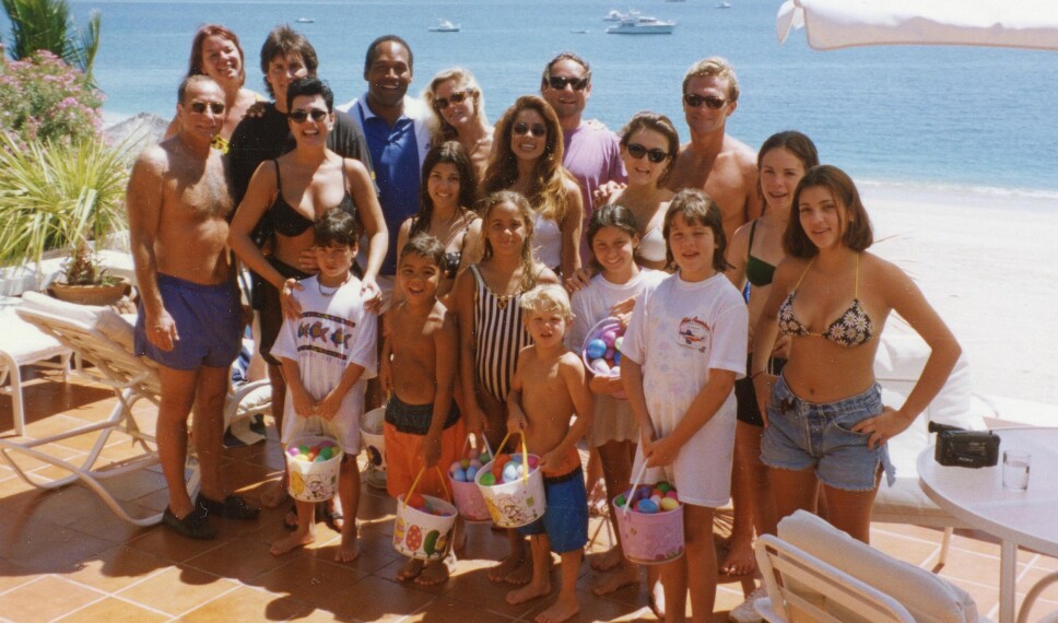 PÅ FERIE: OJ Simpson og ekskona Nicole Brown Simpson, bakerst som nummer tre og fire fra venstre, avbildet på ferie med Kardashian-/Jenner-klanen i 1994. Foran fra høyre - Kim Kardashian, Khloe Kardashian. Kourtney Kardashian og Robert Kardashian sees ved siden av mamma Kris Jenner (sort bikinitopp).