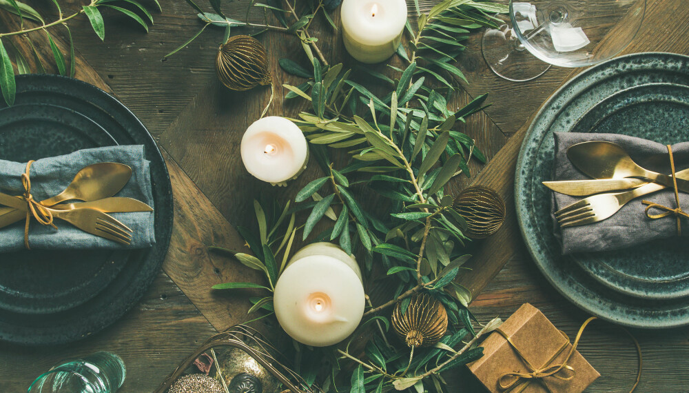 Dekk bordet med grønne planter, eller legg mose og kongler i en skål sammen med julekuler - enkelt og lekkert.