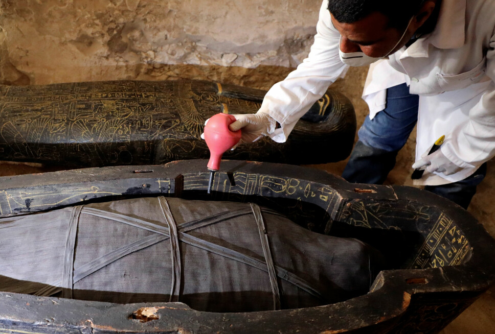 En arkeolog arbeider med kisten etter åpningen.