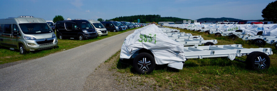 BOBILCHASSIS: Bybobiler til venstre. Til høyre chassis som skal få påmontert en boenhet.