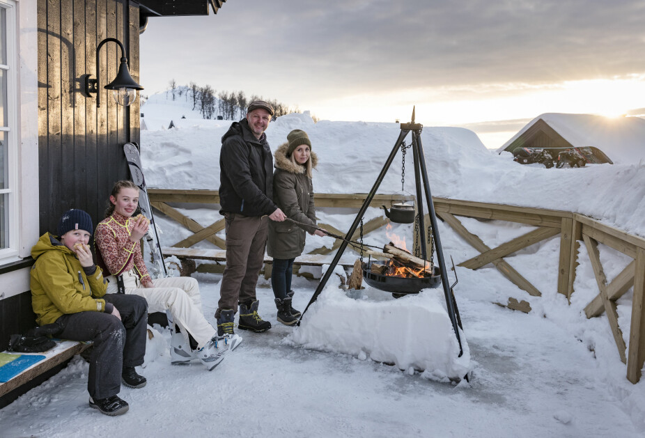 Utekos. Selv om det er veldig mye snø rundt hytta, har familien gravd frem verandaen og laget en koselig plass med bålpanne. Når sola står høyt, er det lunt og godt der.