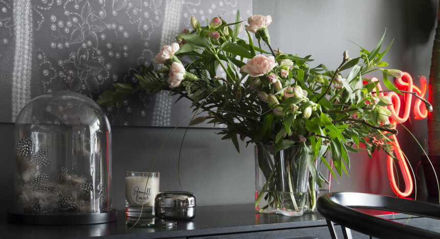 SKEPTISK: Grønne planter myker opp den mørke stramheten. Og Yes-lampen fra Lagerhaus henter opp den oransje fargen fra bokhyllen og skaper dybde i rommet.