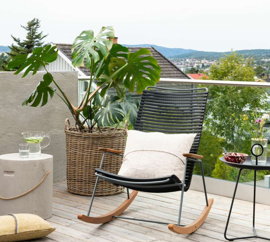 INNRAMMET: Sonen mot nord er mer eksponert mot omgivelsene. Her er terrassen rammet inn av et rekkverk i glass. Gyngestol og sidebord fra Skeidar, puter fra Teixidors, vannmugge fra Eva Solo.