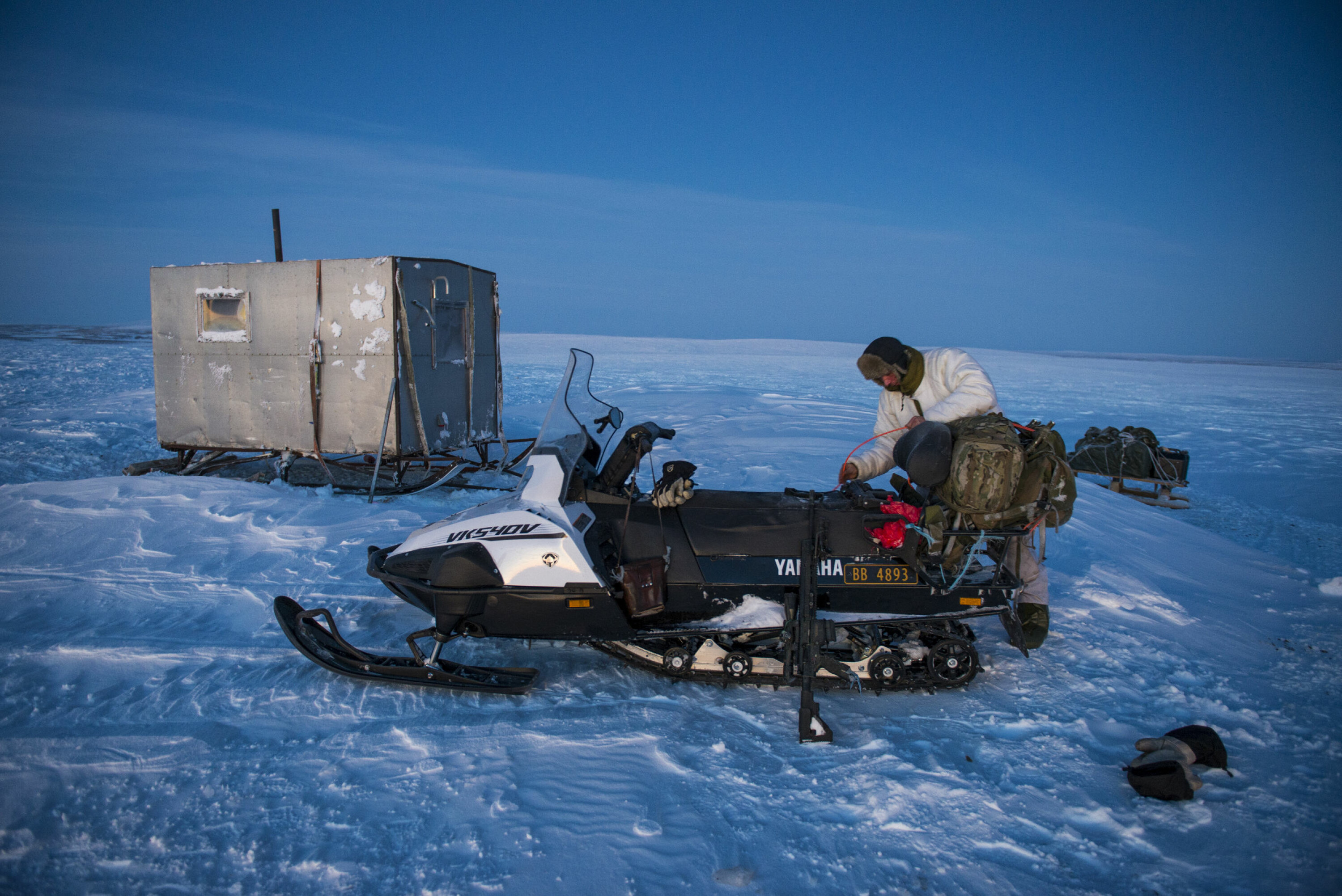 KULDE: John Anders forbereder scooteren til hjemturen i skumringen. Bakgrunnen som reindriftssame gjør ham bedre i stand enn de fleste til å klare seg en vinternatt ute.