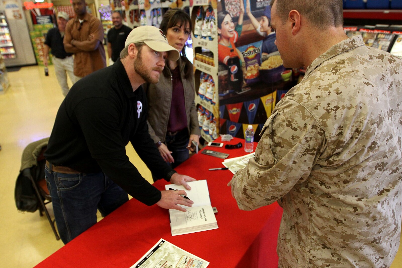 <b>BOK:</b> I 2012 skrev Chris Kyle selvbiografien «American Sniper». På bildet signerer han bøker med kona Taya Kyle ved sin side.