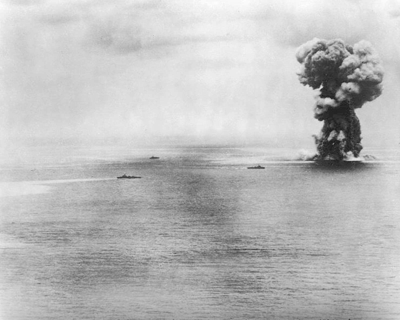 <b>TIL BUNNS:</b> Da ammunisjons­lageret i baugen på Yamato eksploderte steg soppskyen seks kilometer til værs. Fartøy­ene rundt gir et inntrykk av dimensjonene