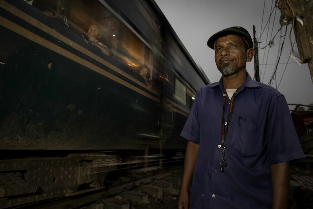 <b>12 TIMERS SKIFT:</b> Abdur Raja vokter en planovergang i Dhakas slum. Hans oppgave er å stenge bommene i hver ende når togene kommer. Han tror det vil bli langt færre ulykker når de ulovlige husene og butikkene ved toglinjene blir fjernet.
