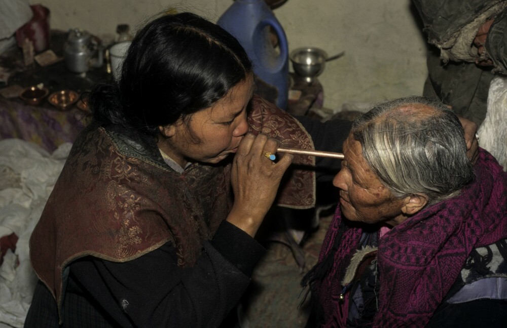 <b>SUGER UT ONDSKAP OG SMERTE:</b> Sjamanen i Himalaya, en Lhamu, i full aksjon idet hun suger ut smerte fra øyet til en gammel kvinne. Hun hevdet å kunne fjerne både smerte, besettelser og andre plager, ved å suge det ut.