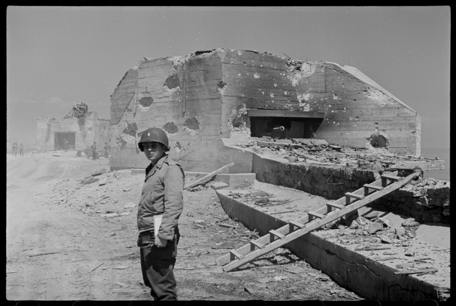<b>ATLANTERHAVSVOLLEN:</b> En amerikansk soldat poserer foran en skadet tysk artilleribunker.