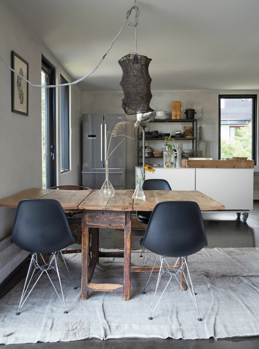 ANTIKT OG DESIGN: Spiseplassen består av et antikt bord og Eames-stoler som er kjøpt brukt. Gulvteppet er fra Private 0204, et dansk firma som redesigner vintagetepper, og bildet på veggen er av Embla Maria Øverbye. Taklampen med strikket skjerm er Vigtel Høllands egen design, som hun også selger på slowdesign.no. ANTIKT OG DESIGN: Spiseplassen består av et antikt bord og Eames-stoler som er kjøpt brukt. Gulvteppet er fra Private 0204, et dansk firma som redesigner vintagetepper, og bildet på veggen er av Embla Maria Øverbye. Taklampen med strikket skjerm er Vigtel Høllands egen design, som hun også selger på slowdesign.no.