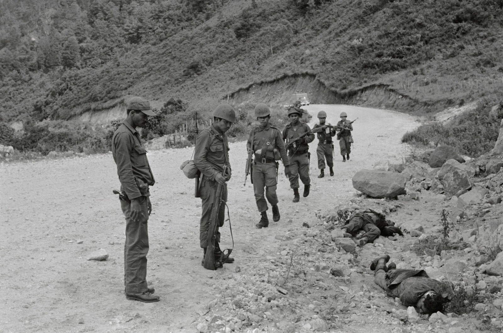 <b>DØDENS GRØFT:</b> Honduranske soldater kikker på falne fiender fra El Salvadors hær etter en trefning under den såkalte Fotballkrigen for 50 år siden. 