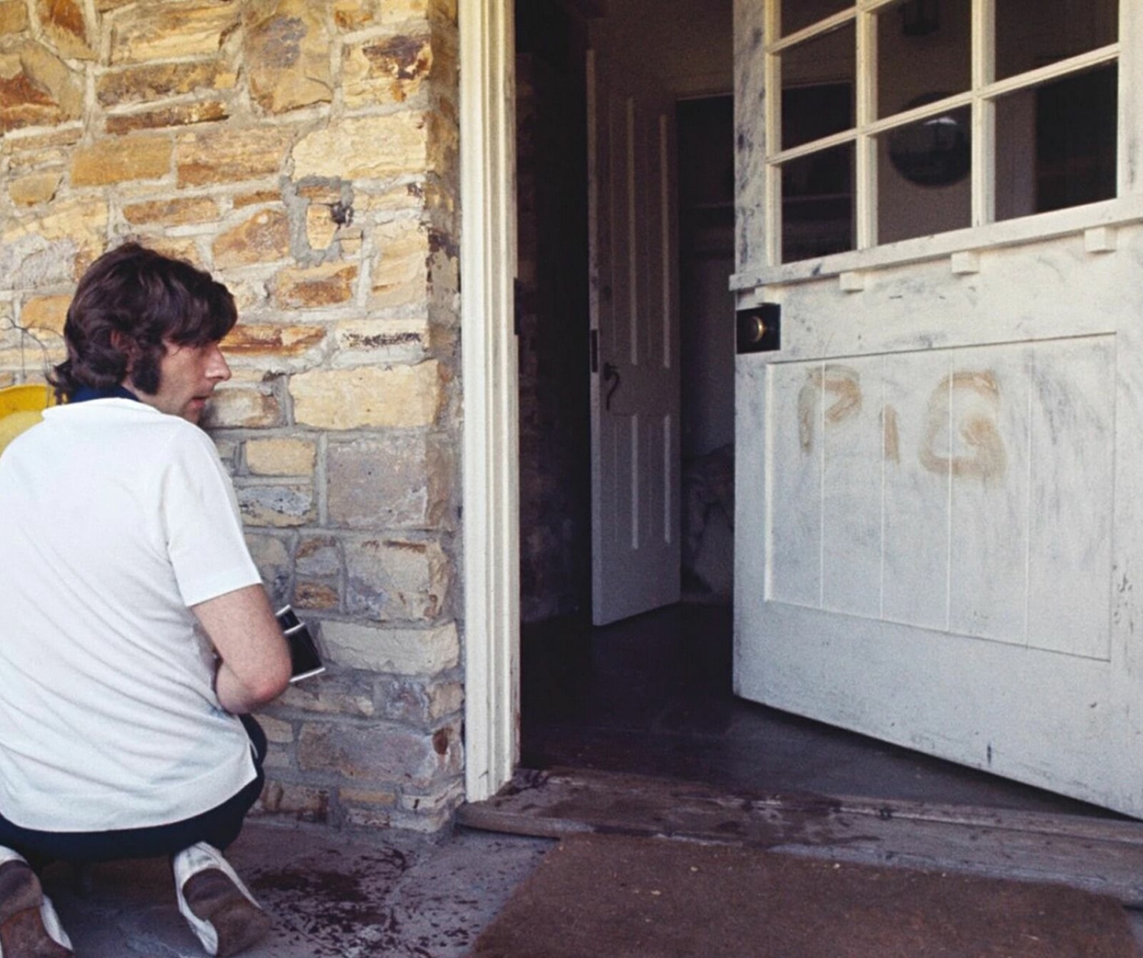 <b>I SJOKK:</b> Roman Polanski ved inngangsdøren til hjemmet, dagen etter massakren i Beverly Hills. Susan Atkins skrev ordet med hans kones blod. 
