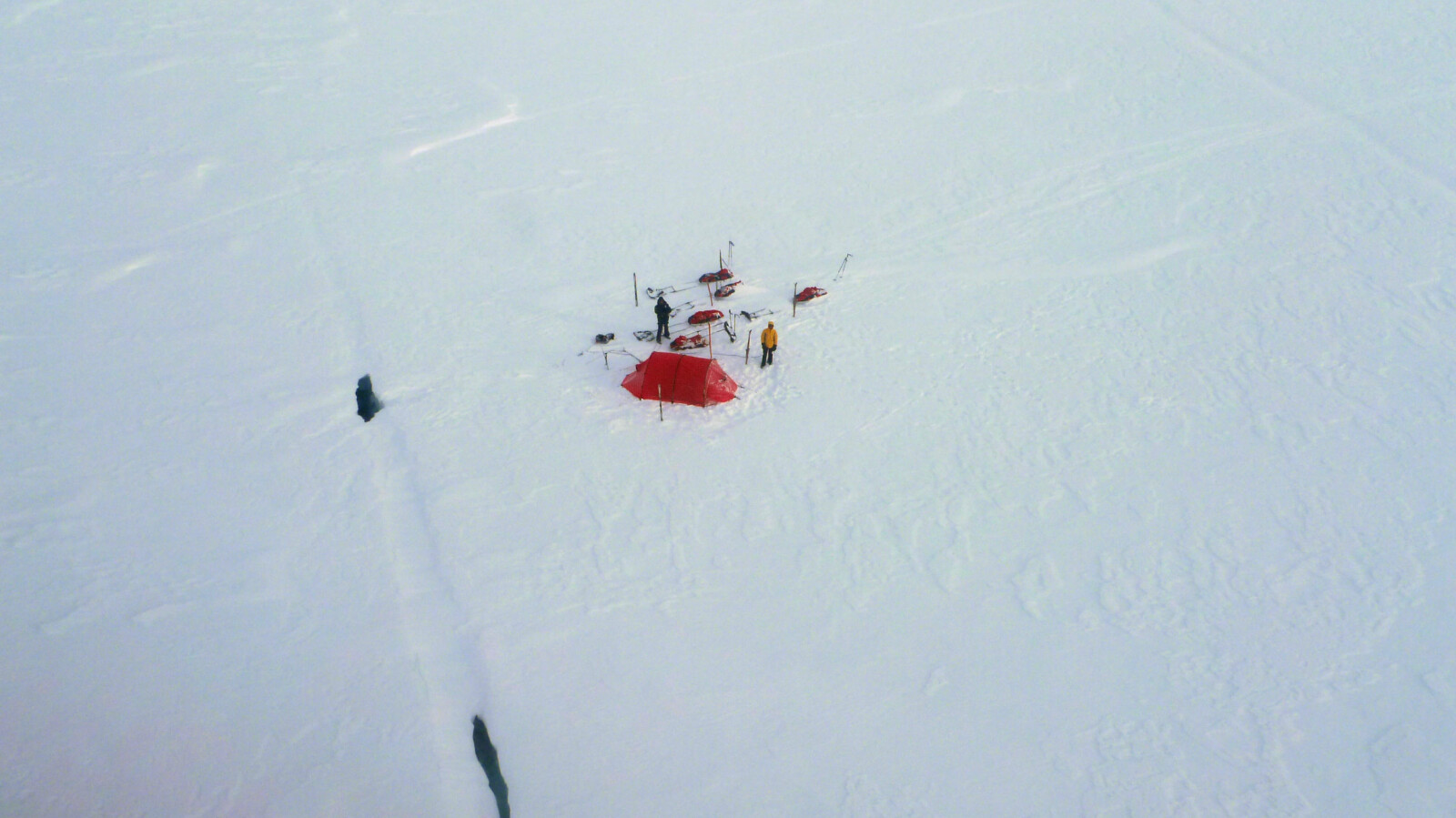 <b>BUNNLØS SPREKK:</b> Her, i det øverste hullet, falt Svalbard-guiden Brent D’Hooge mens skituristene sto lamslåtte igjen på overflaten. Bildet er tatt fra redningshelikopteret seks timer senere.