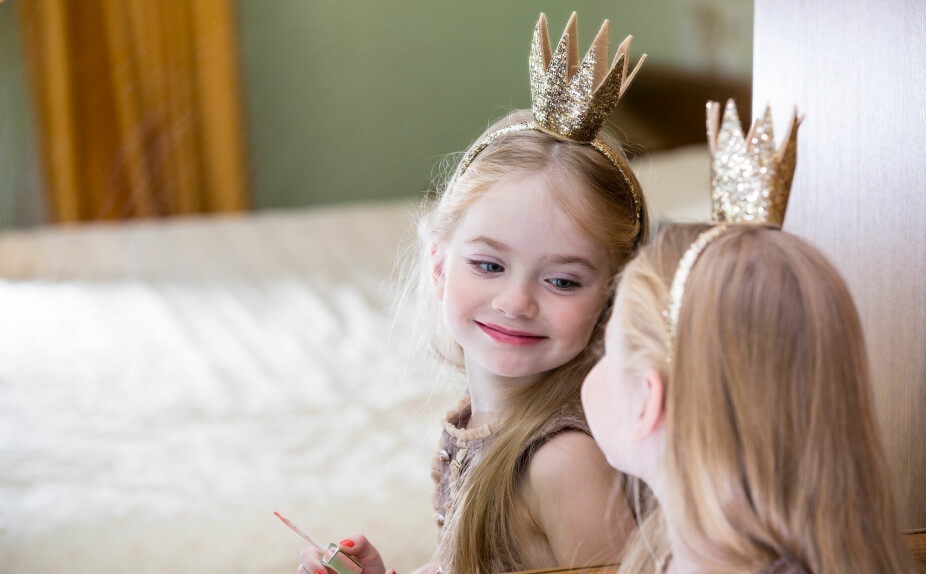 FOKUS PÅ UTSEENDE: En jente med prinsessekrone ser seg selv i speilet. Dora Thorhallsdottir mener mange jenter man tar med seg skjønnehtsfokuset fra ung alder og videre gjennom livet.