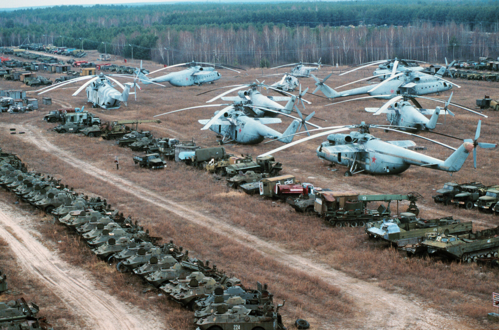 <b>LANDET FOR ALLTID:</b> Helikoptrene ble brukt til å dumpe slukkemidler på den brennende Tsjernobyl-reaktoren. Og så landet de på den hermetisk lukkede fartøyskirkegården. Militære kjøretøyer som ble brukt, gir dem selskap.