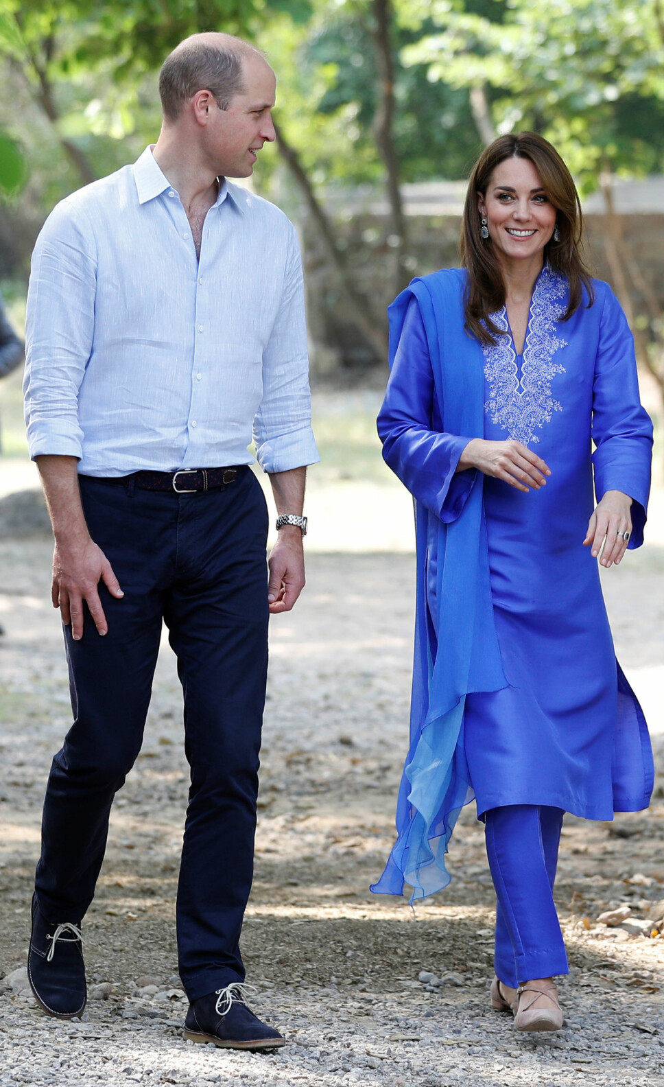 BLÅTT PAR: Prins William gikk for lyseblå skjorte akkompagnert av mørkeblå bukser og matchende sko. Hertuginne Kate hadde på seg en tradisjonell kurta med tilhørende skjerf over skulderen og nude sko med hæl.