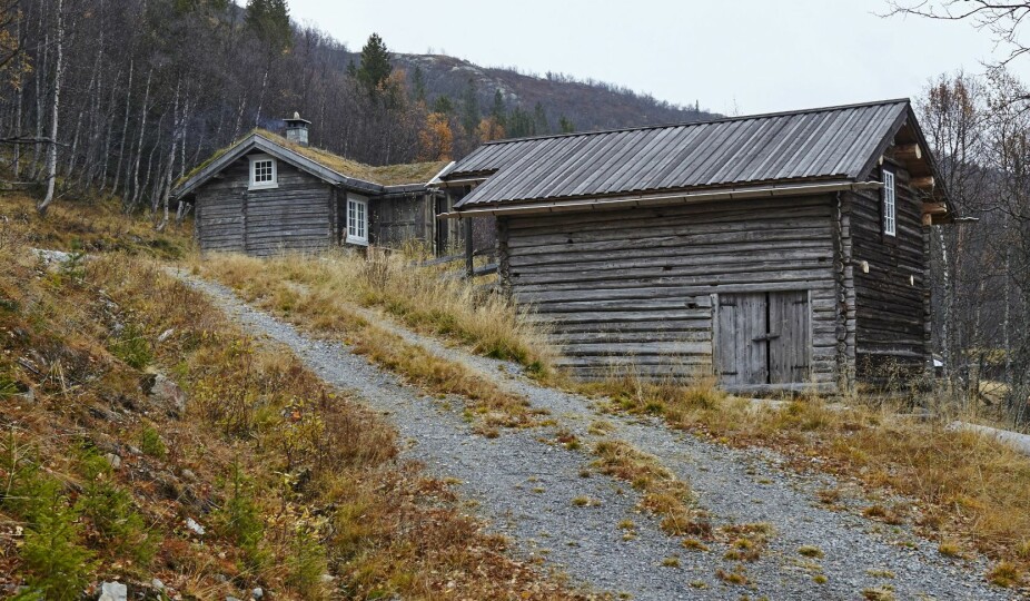 MANGE MULIGHETER: Den gamle låven har Anne Kari planer for. Første etasje er uinnredet, mens det i andre etasje er satt inn ett stort spisebord som brukes til festlige lag. Låven i forgrunnen har fått nytt tretak.