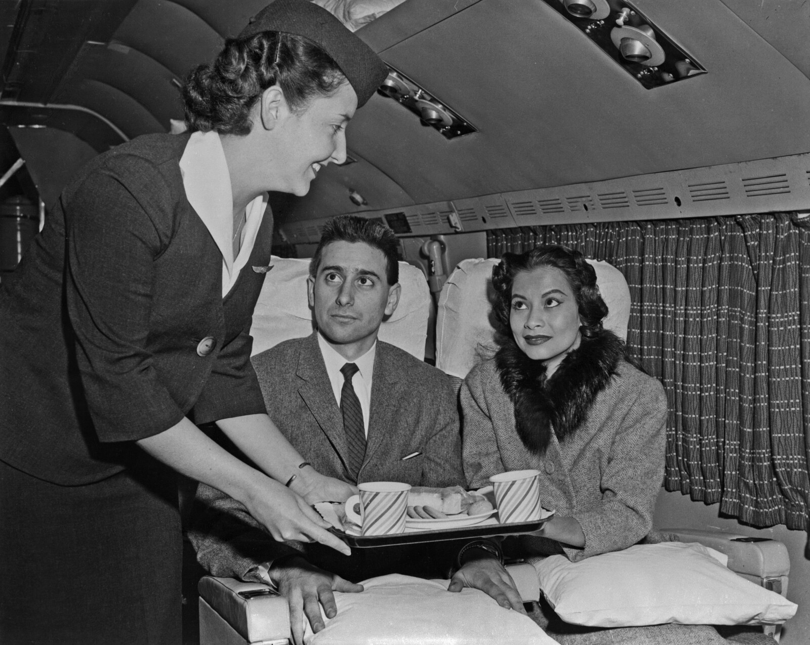 <b>SERVERING:</b> To passasjerer serveres litt snacks på Transocean Air Lines Boeing 377 på midt av 50-tallet.