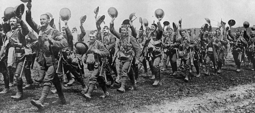 <b>FREIDIG TIL FRONTEN:</b> Engelske soldater fra Worcester­shire Regiment vinket fornøyd med hjelmene på vei til slag­marken første dagen av slaget ved Somme. I løpet av én måned var hver fjerde soldat drept.