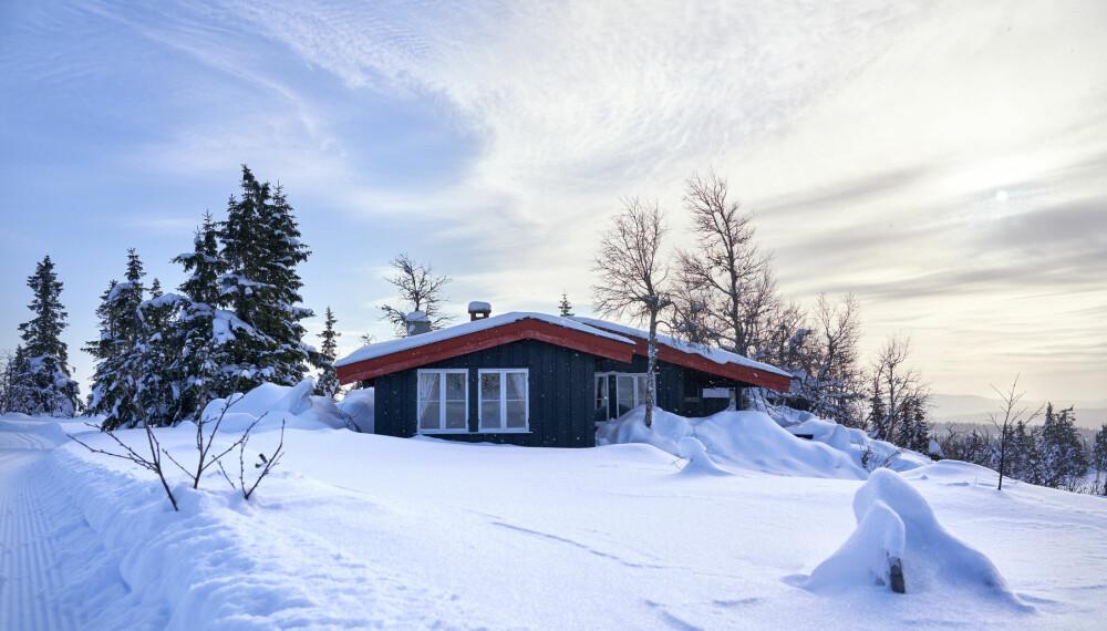 HYTTEDRØMMEN: En liten hytte avbildet etter kraftig snøfall i Oppland.