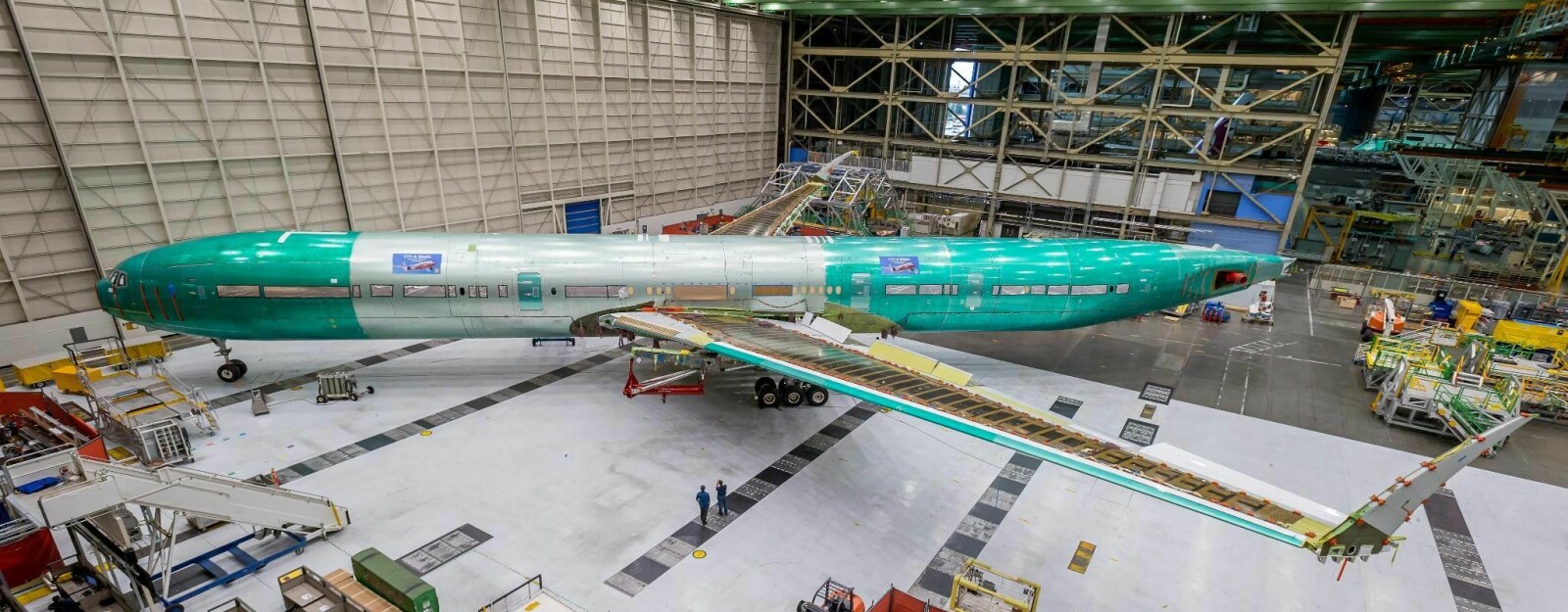<b>PROTOTYPE:</b> Det første eksemplaret av 777 X er kommet ut av produksjons­linjen til Boeing-fabrikken. Vingespennet er så enormt at vingene har fått oppfellbare vingetipper for å passe inn på flyparkerings­-<br/>plassene. 