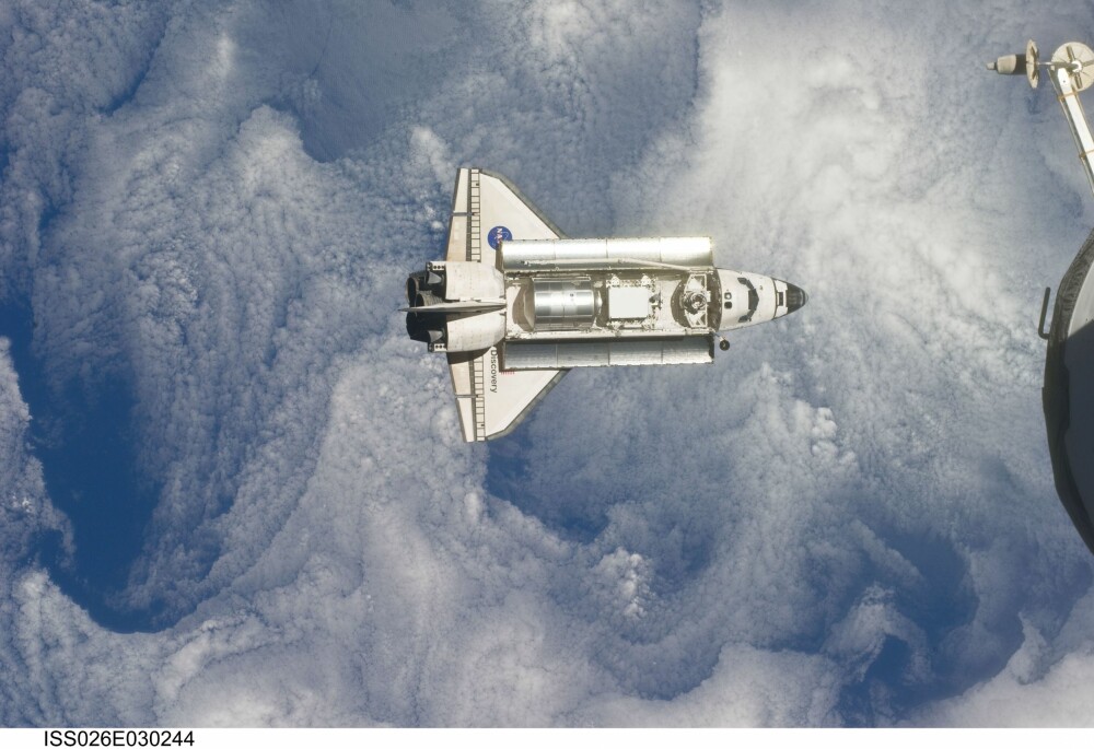 <b>SISTE REIS:</b> Romfergen Dicovery sett fra Den internasjonale romstasjonen, på Discoverys aller siste ferd i februar 2011. Discovery var romfergen med flest turer i rommet. I løpet av 27 år ble det 39 romferder.