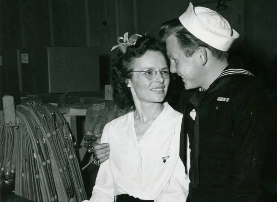 MOR OG SØNN: Vera Staples-Mueller og Elgin Staples. I bakgrunnen til venstre kan man skimte livbeltene som trolig er av samme type som reddet Elgins liv to ganger. De fortalte sin historie både til lokale aviser og radiokanaler.