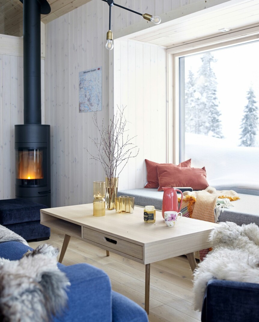 LUFTIG: Selv om stuen er liten, gjør den romslige takhøyden den til et godt sted å være. Her er det bare å la tankene fly. Peis fra Jøtul, bord fra Ikea.