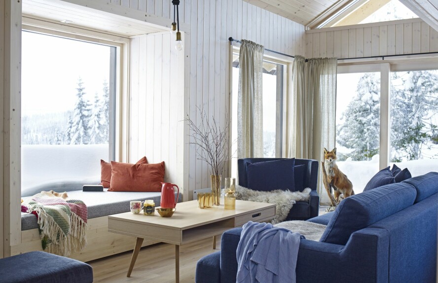 LUFTIG ALLROM: Stuen har vinduer på tre vegger og i gavlen. Det gir mengder med dagslys i rommet og gjør at det virker større enn kvadratmeterne skulle tilsi. Bak sofaen ligger kjøkkenet med spisebord.