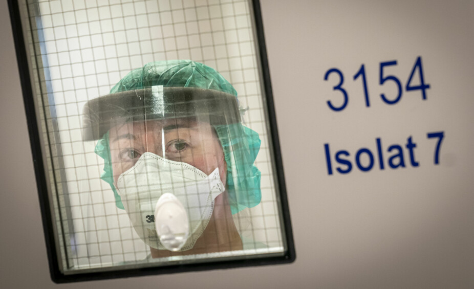 ISOLAT: Fagutviklingssykepleier Marte Rygh Selmer ikledd smittevernutstyr ser ut av en sluse på isolatposten på Ullevål sykehus. Arkivfoto, Heiko Junge / NTB scanpix