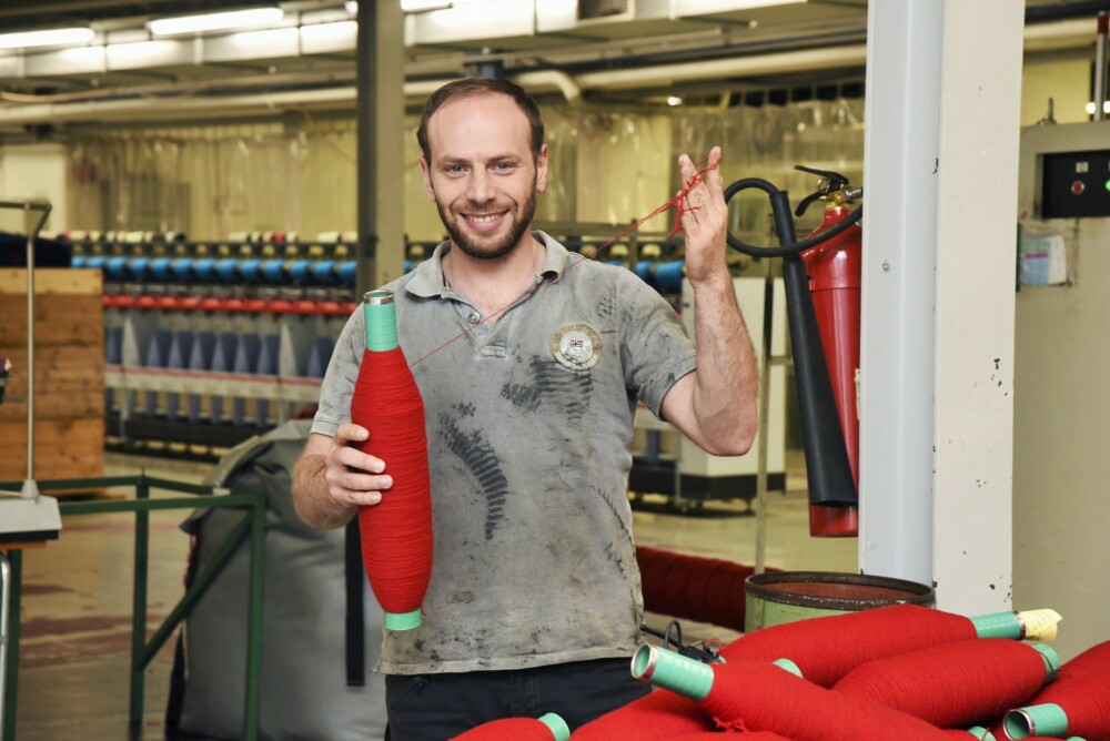 <b>GLAD:</b> Jeg er glad for at jeg bidrar til samfunnet, sier Ahmad, tekstilingeniør på Gulbrandsdalen Uldvarefabrikk.  