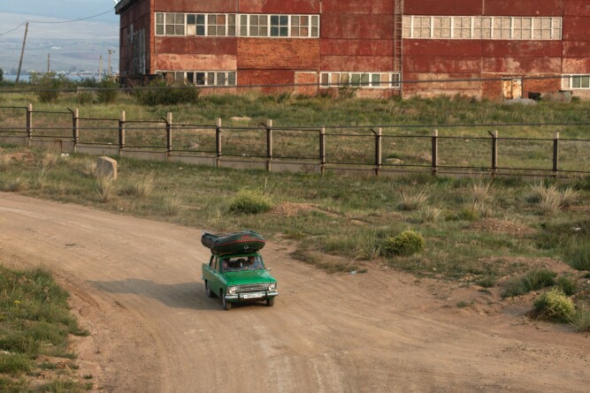 <b>MONGOLIA:</b> Bil og båt på vei og nedlagt fabrikk i bakgrunnen. 
