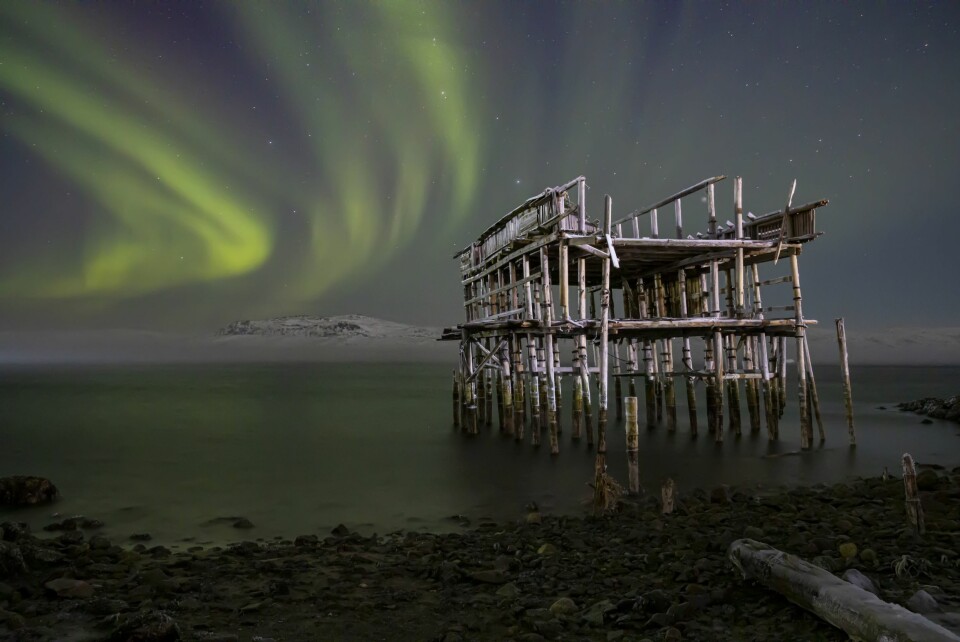 REISENS MÅL: Nordlyset skinner over en gammel brygge i Teriberkas verden. Det er dette de kinesiske turistene kommer for å oppleve.