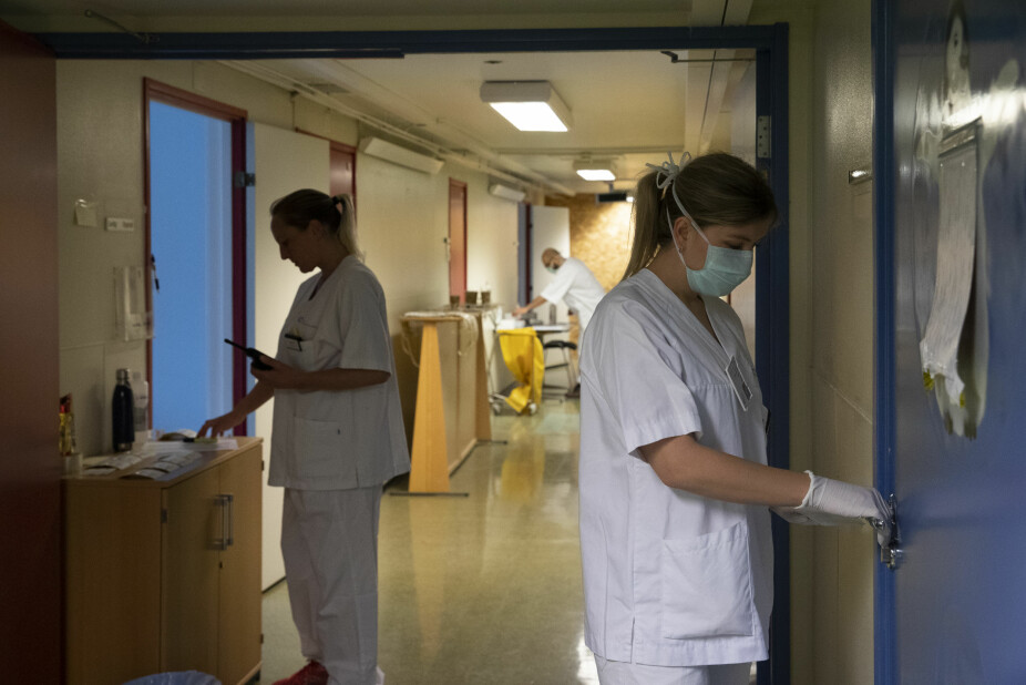 MÅ JOBBE PÅ EN HELT NY MÅTE: Sykepleier Ingrid Seim venter ved døra bak testrommet på koronatest fra en av de ansatte på sykehuset. Heidi Poetzsch styrer kommunikasjonen på lukket samband og holder orden på pasientlistene. Bioingeniør Hassan Alhassani jobber i bakgrunnen.
