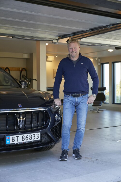 – Jeg er genuint opptatt av bil, sier Svein-Erik Knutsen og poserer med sin Maserati Levante Suv.