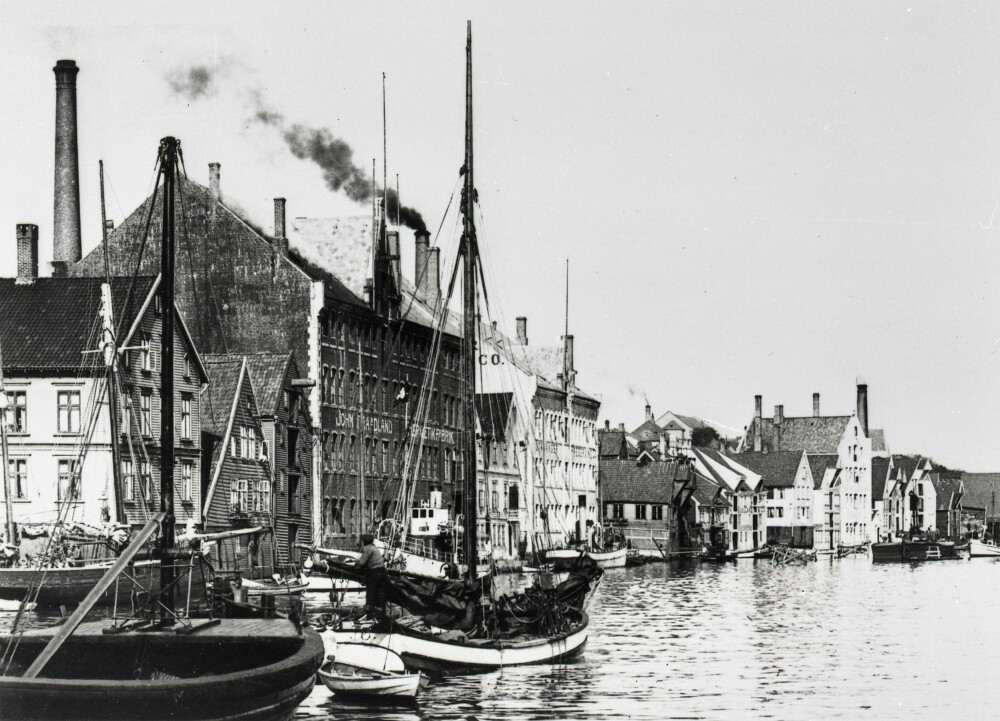 <b>HERMETIKKBYEN:</b> Langs Strandkaien i Stavanger lå hermetikkfabrikkene og fiskebåtene tett rundt år 1900. Legg merke til de mange fabrikkpipene! Foto: Stavanger Byarkiv