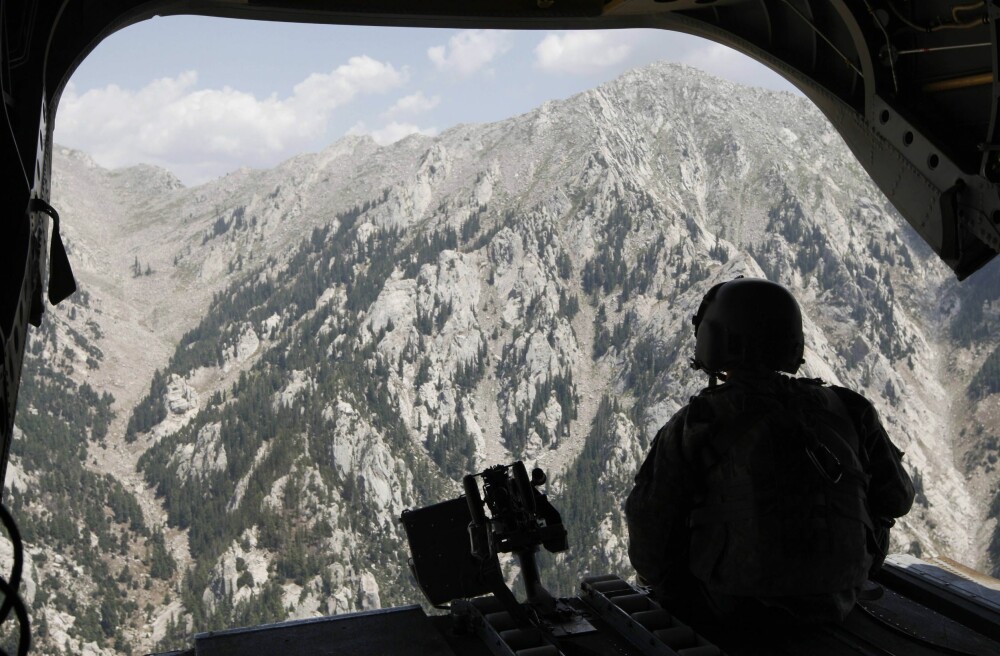<b>DØDELIG TERRENG:</b> En haleskytter ser ut over fjellene i Kunarprovinsen i nordøst-Afghanistan fra et CH47 Chinook-helikopter. Her var Taliban på hjemmebane, og det var i dette området amerikanske spesialstyrker mistet 19 mann under et feilslått oppdrag for 15 år siden. 