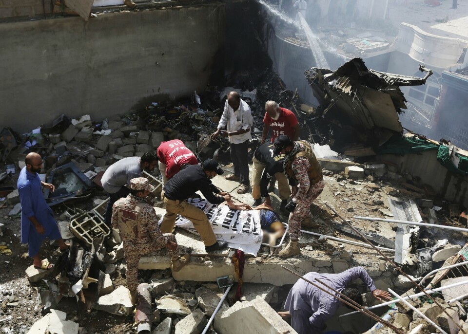 BOLIGOMRÅDE: Deler av ulykkesflyet havnet på hustakene. At havaristedet var en trang gate, gjorde kaoset og opprydningen vanskelig for redningsmannskapene.