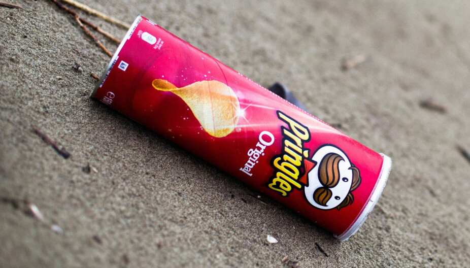 ENDRES: En tom boks med Pringles-chips er avbildet etter at de er blitt kastet fra seg på en sandstrand. Nå varsler produsenten at de vil lansere en mer miljøvennlig emballasje til den verdenskjente snacksen.
