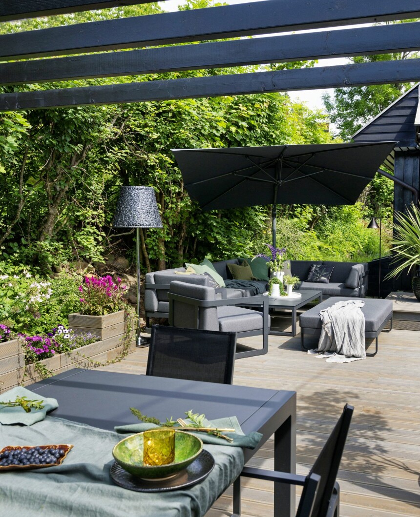 GRØNT OG LILLA: Blomsterkassene er snekret av overflødige terrassebord. For å gi terrassen dimensjoner er de lagt i ulike høyder. Siri er aller mest glad i grønne planter og ville ikke ha for mange farger, så hun har, litt nerdete ifølge seg selv, valgt lilla som gjennomgangsfarge på blomstene. Loungemøblene i bakgrunnen er fra Fine Design. Stålampen fra KTribe-serien til Flos er designet av Phillippe Starck. – Jeg elsker den lampa, den gir helt rått lys om kvelden!