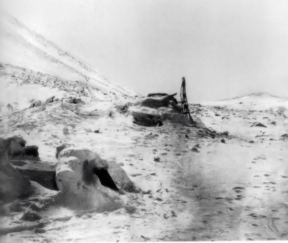 <b>KRYPINN:</b> Inngangen til Nansen og Johansens vinterhytte på Frans Josefs land i forgrunnen til venstre. I bakgrunnen er en av sledene stilt på høykant.