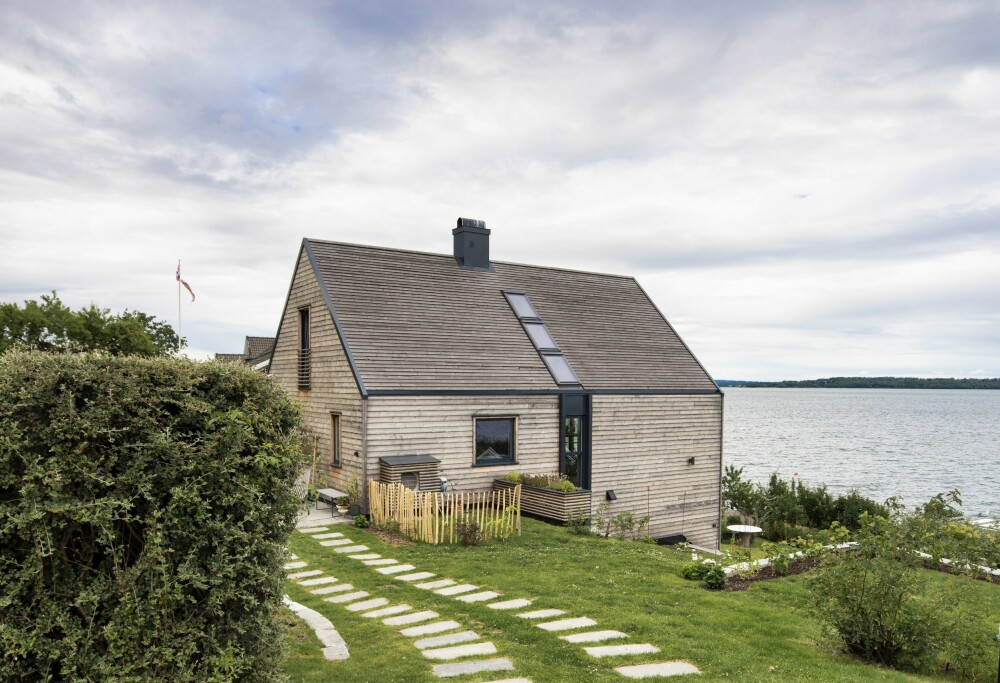 Huset nær havet i Åsgårdstrand, er kledd med treverk både på vegger og tak. Den skrånede tomten leder ned til egen badeplass. Huset er tegnet av arkitekt Rune Breili.