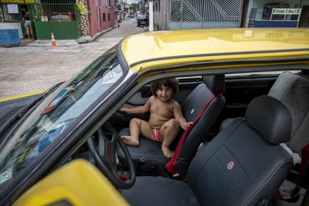 <b>I PAPPAS BIL:</b> Dette er også inne i Vila Da Barca favelaen. Men Inês fortalte at deler av favelaen har, takket være donasjoner utenfra, blitt modernisert. Her sitter gutt­ungen Edison i pappas gule bil.